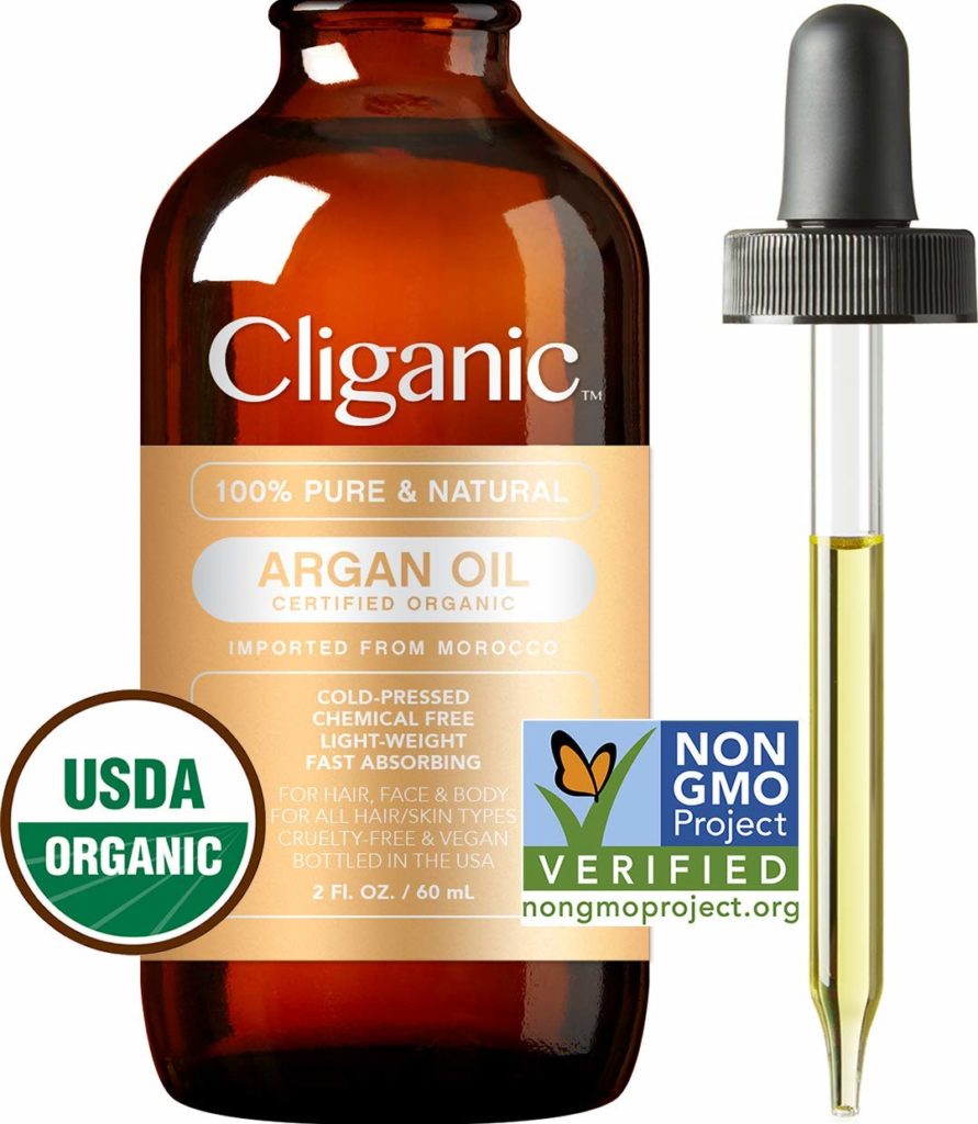 Bottle of argan oil with argan nuts in the background